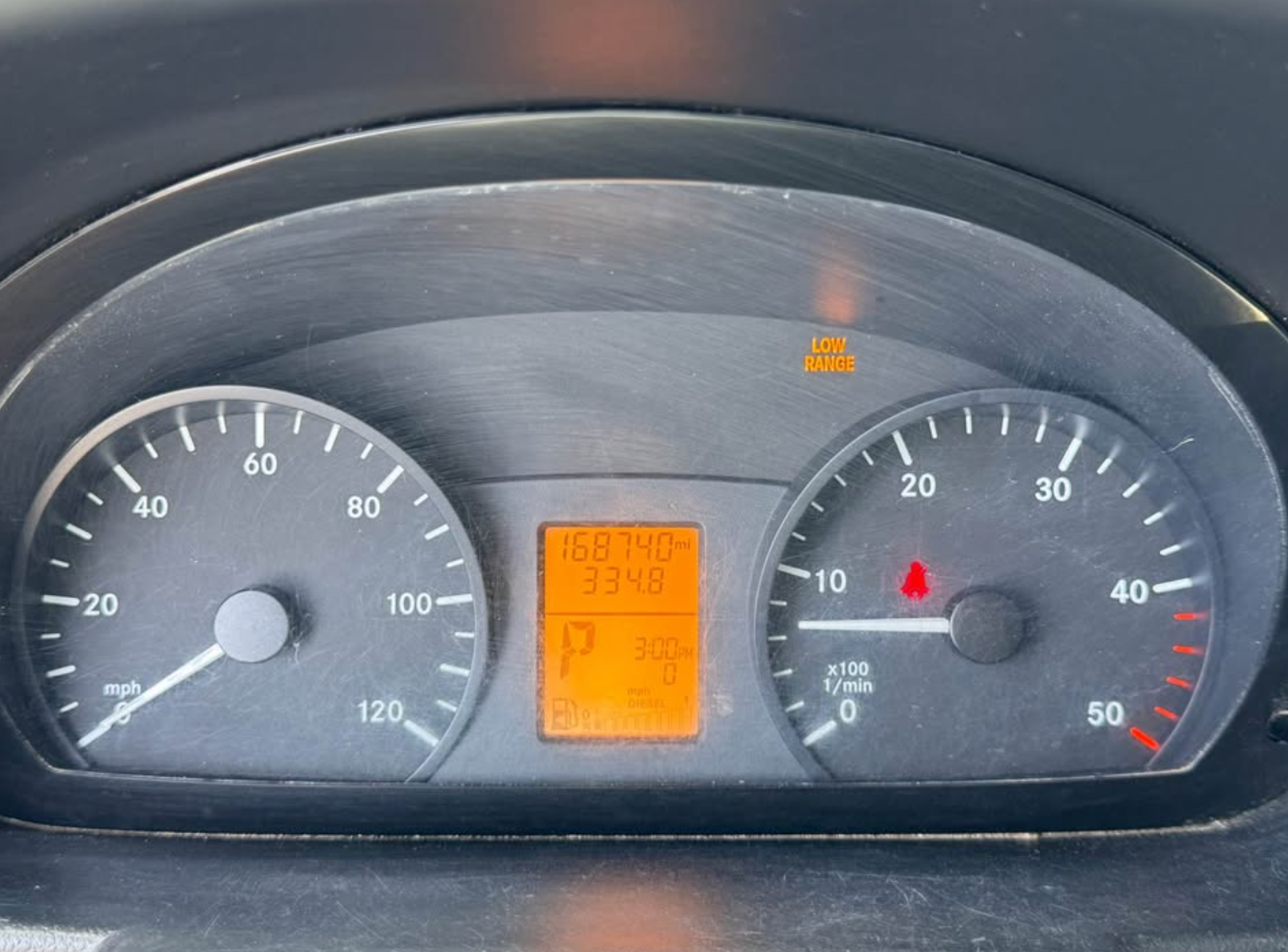 Car dashboard with speedometer and digital display showing fuel level and temperature.