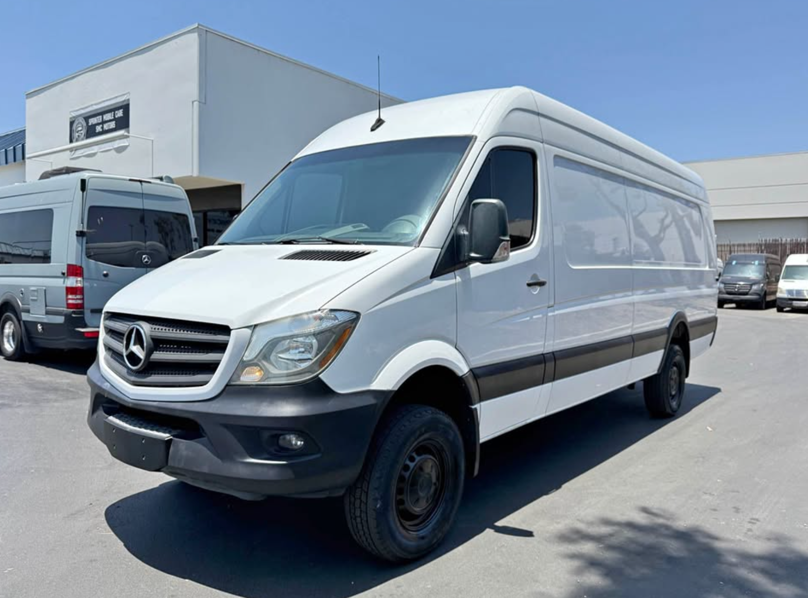 White Mercedes-Benz van parked on a concrete surface with a building in the background